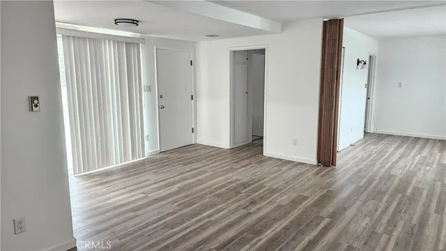 a view of a room with wooden floor and entryway