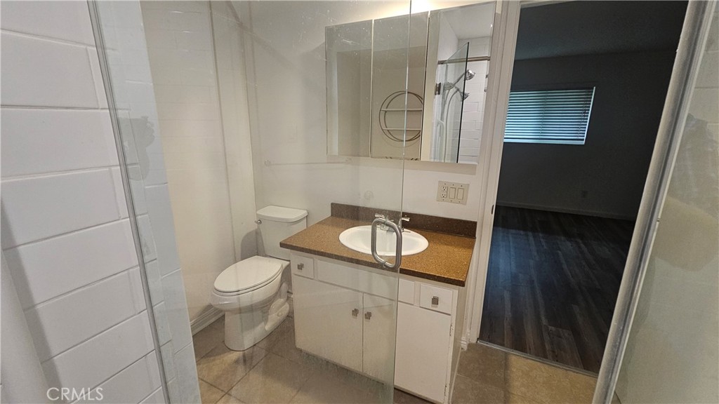 22627 Nadine Circle, Unit B Torrance, CA 90505 - Photo 9 of 16 a bathroom with a granite countertop sink toilet and mirror