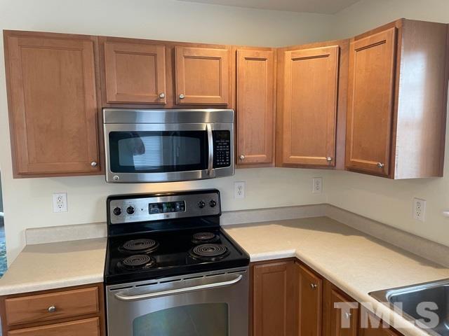 7831 Averette Field Drive Raleigh, NC 27616 - Photo 7 of 20 a kitchen with granite countertop a stove and a microwave