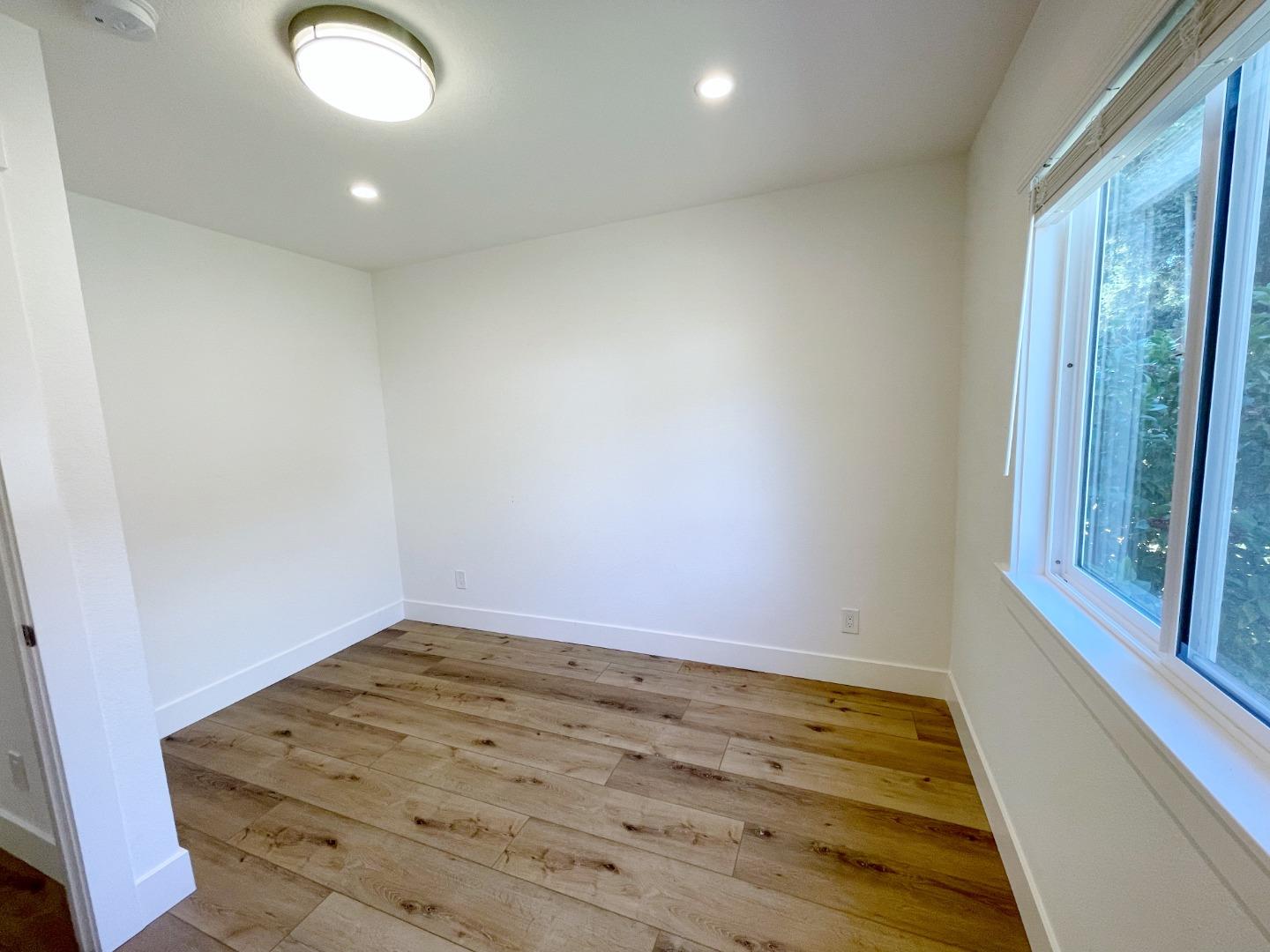 808 Sonia Way Mountain View, CA 94040 - Photo 14 of 20 an empty room with wooden floor and windows