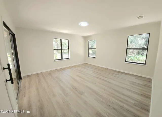 wooden floor in an empty room with a window