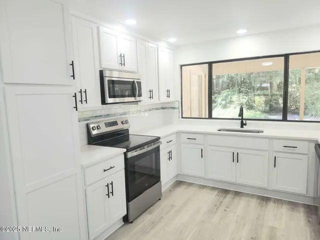 a kitchen with appliances cabinets and a sink