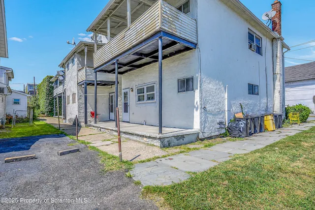 a view of a house with a small yard and sitting area