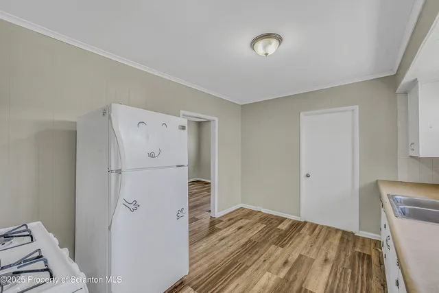 a kitchen with granite countertop white cabinets and white appliances