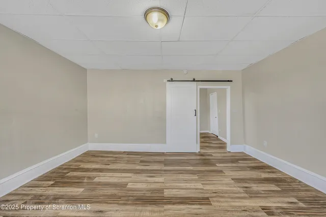 a view of a room with wooden floor and window