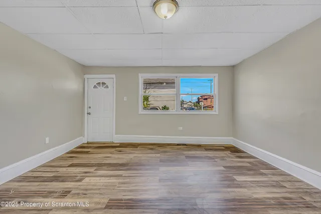 a view of room with window and wooden floor