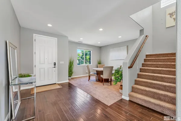 a view of an entryway with wooden floor and a livingroom view