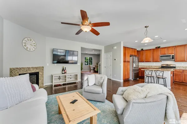 a living room with furniture kitchen view and a window