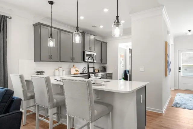 a kitchen with kitchen island a sink stove and refrigerator with wooden floor