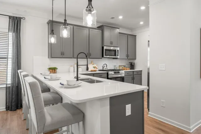 a kitchen with kitchen island a sink counter and chairs