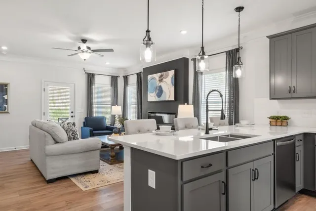 a living room with furniture a chandelier and kitchen view