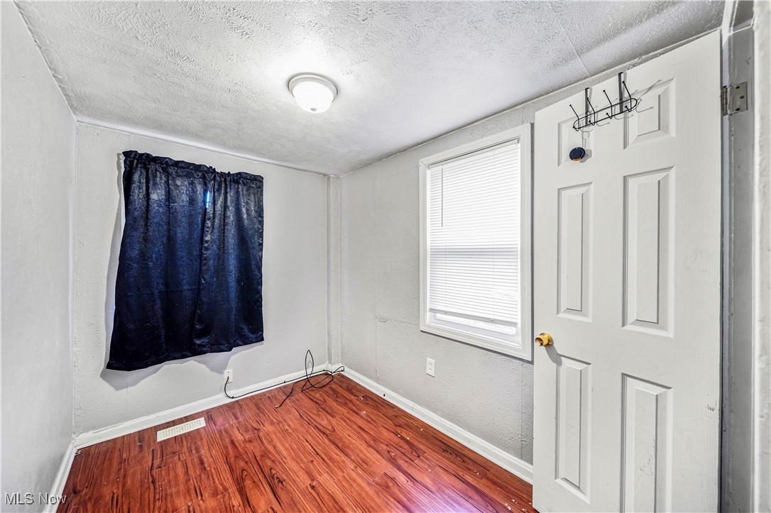 1770 Red Bird Road Madison, OH 44057 - Photo 16 of 23 Unfurnished room with a textured ceiling and wood-type flooring