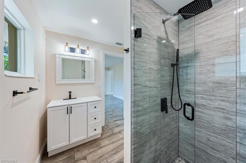2545 Dawn Circle Naples, FL 34103 - Photo 12 of 20 a bathroom with a double vanity sink a mirror and a shower