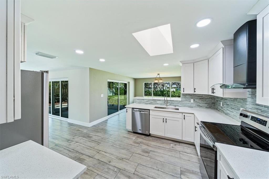 2545 Dawn Circle Naples, FL 34103 - Photo 7 of 20 a kitchen with a stove sink and cabinets