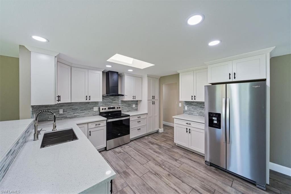 2545 Dawn Circle Naples, FL 34103 - Photo 8 of 20 a kitchen with white cabinets and stainless steel appliances
