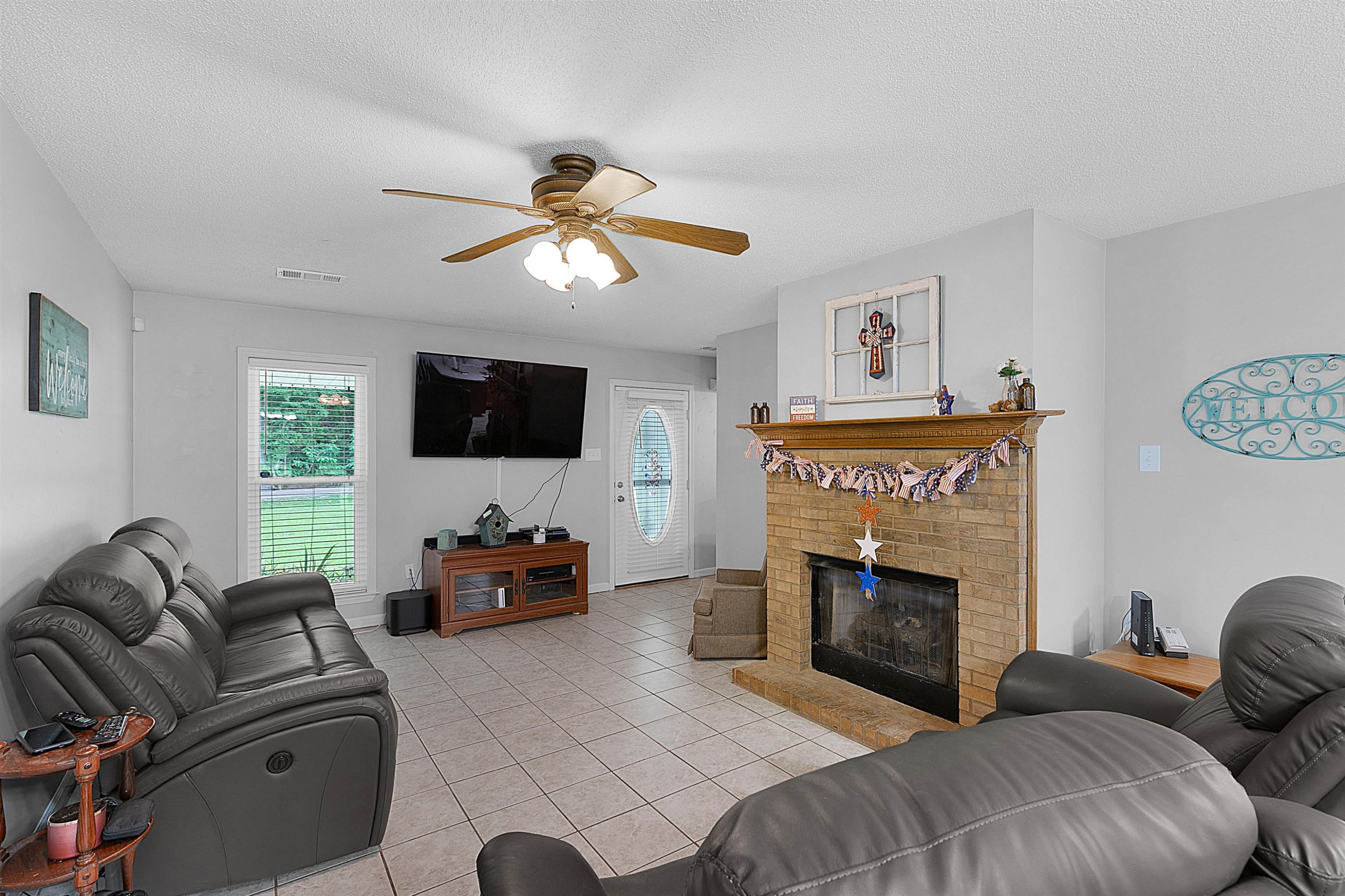 3225 Pickens Store Road Mason, TN 38049 - Photo 16 of 32 a living room with furniture a fireplace and a flat screen tv