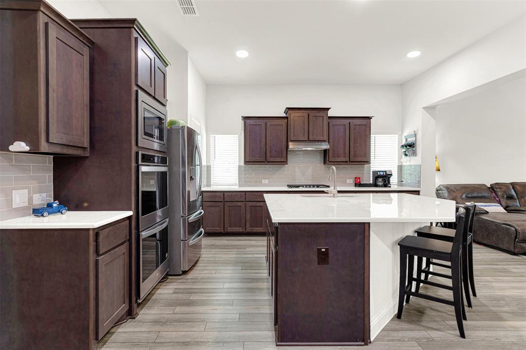 817 Amy Boulevard Anna, TX 75409 - Photo 3 of 40 a kitchen with stainless steel appliances granite countertop a sink stove and refrigerator