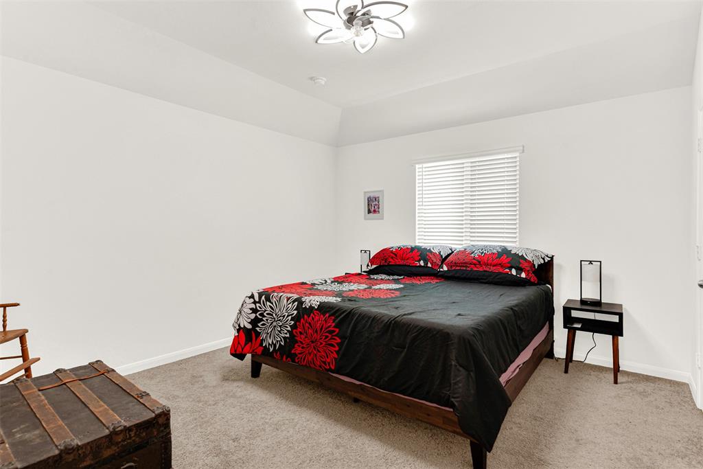 817 Amy Boulevard Anna, TX 75409 - Photo 31 of 40 a bedroom with a bed and a chandelier