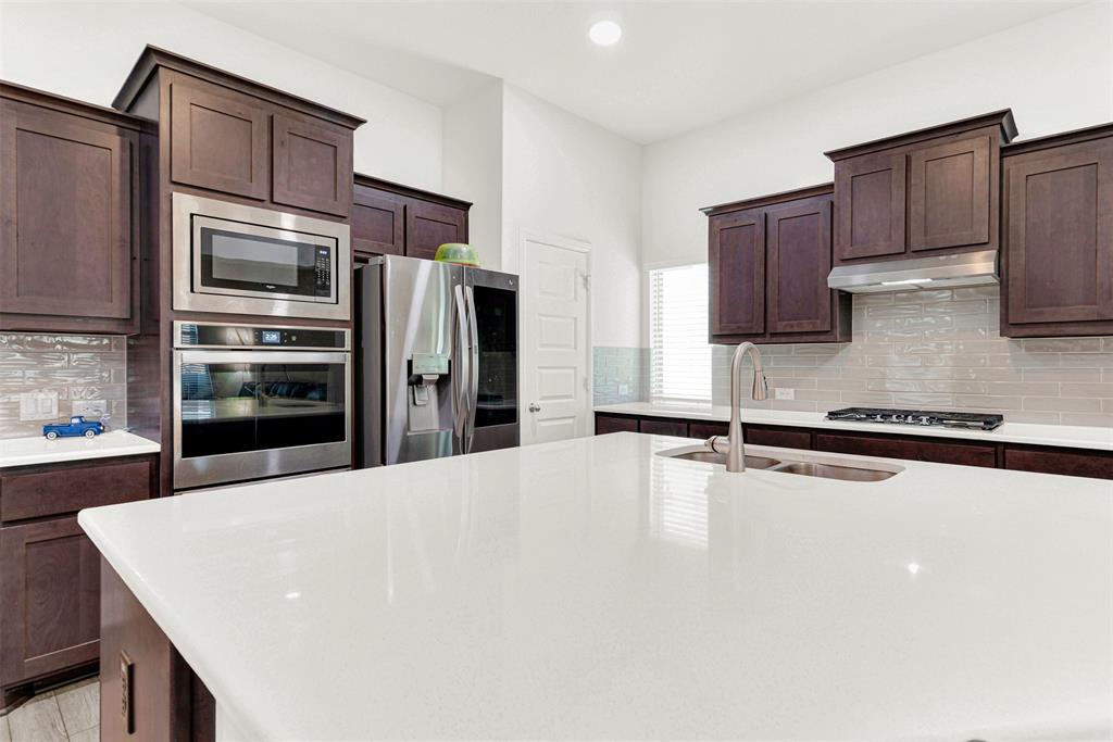 817 Amy Boulevard Anna, TX 75409 - Photo 4 of 40 a kitchen with stainless steel appliances a refrigerator and a stove top oven
