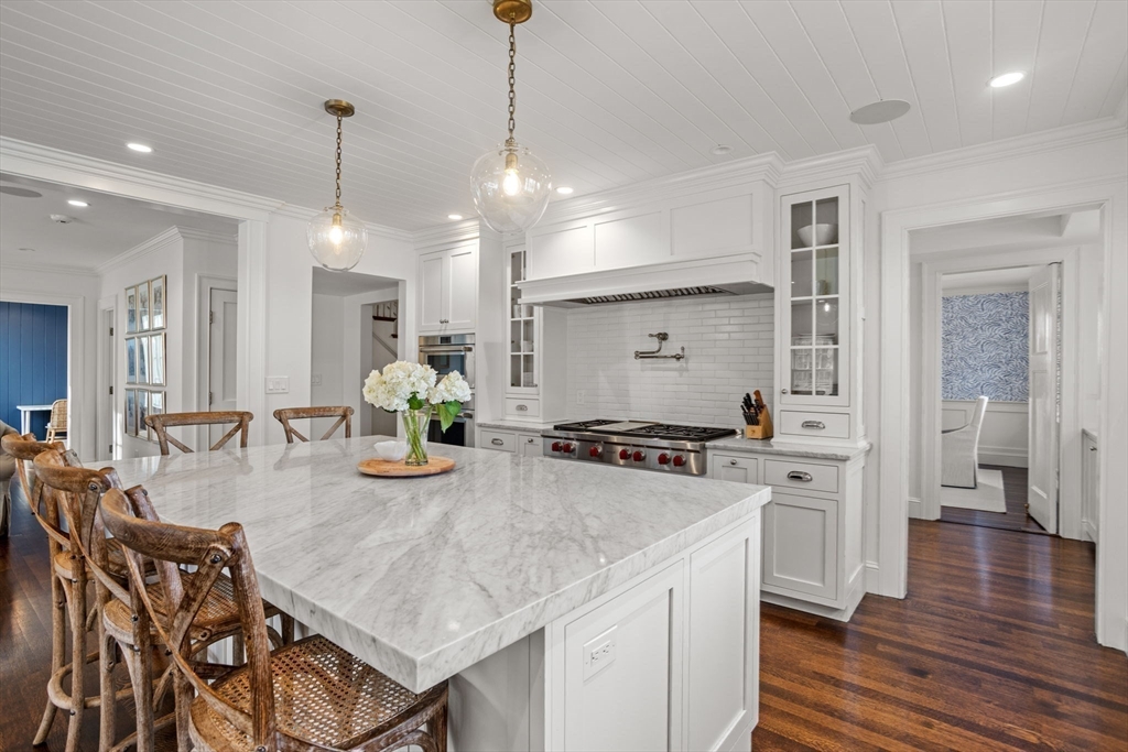 56 Pine Ridge Road Newton, MA 02468 - Photo 5 of 24 a kitchen with stainless steel appliances granite countertop a stove a sink a refrigerator a dining table and chairs with wooden floor