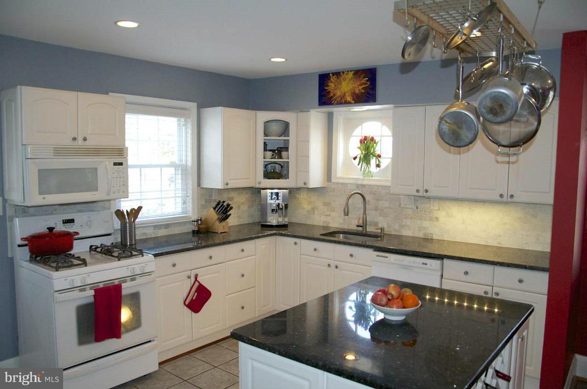 525 Windwood Road Baltimore, MD 21212 - Photo 2 of 6 a kitchen with stainless steel appliances granite countertop a sink a stove and a wooden cabinets