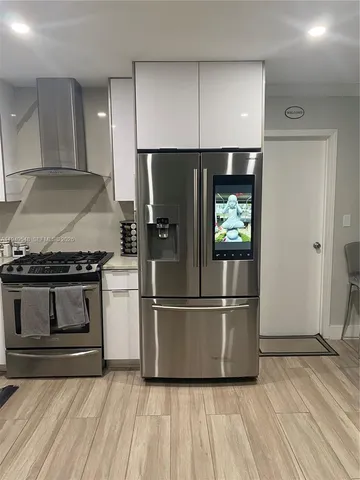 a metallic refrigerator freezer sitting in a kitchen