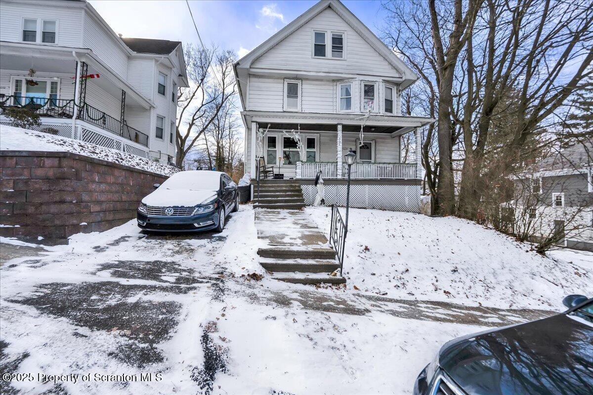 Undisclosed Address Scranton, PA 18509 - Photo 2 of 26 a front view of a house with a yard covered in snow