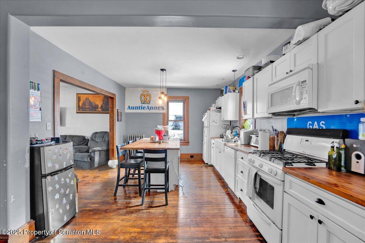 Undisclosed Address Scranton, PA 18509 - Photo 5 of 26 a kitchen with stainless steel appliances granite countertop a stove top oven a sink a dining table and chairs with wooden floor