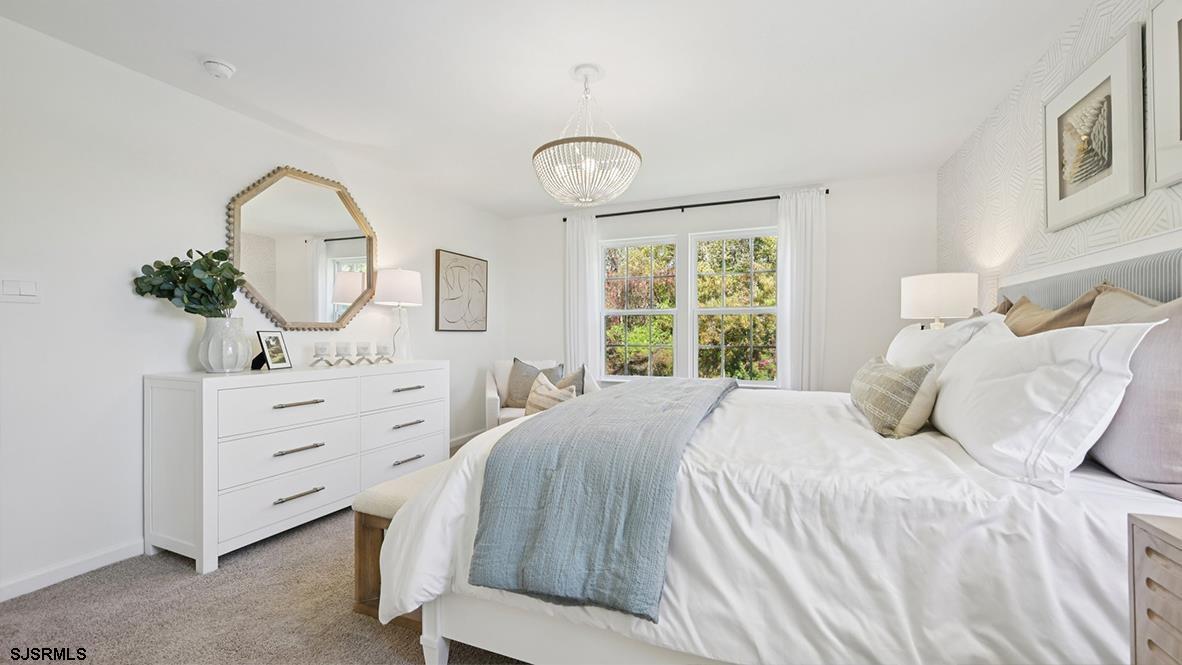 2 Dalton Way, Unit 201 Rio Grande, NJ 08242 - Photo 31 of 43 a bedroom with a bed a mirror on dresser and a window