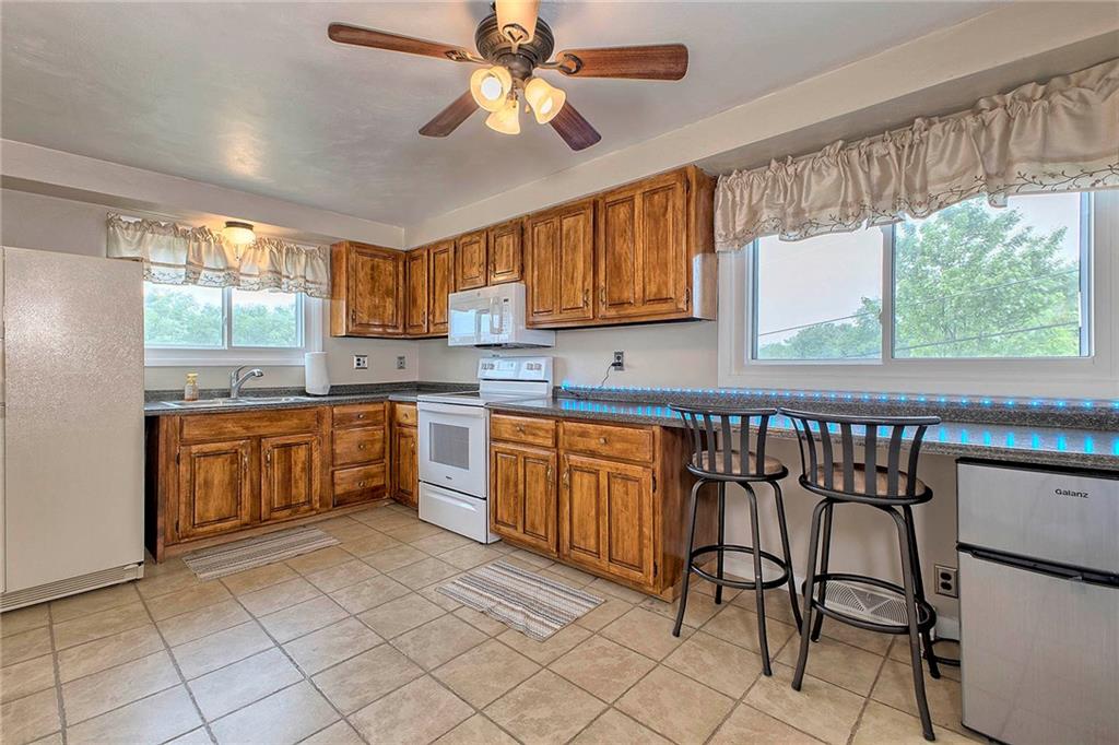 8002 Hayward Street Irwin, PA 15642 - Photo 12 of 31 a kitchen with stainless steel appliances granite countertop a stove top oven a sink a dining table and chairs