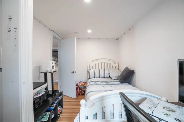 a bedroom with a bed and wooden floor