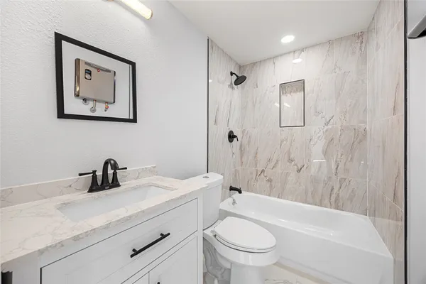 a bathroom with a sink a toilet and shower