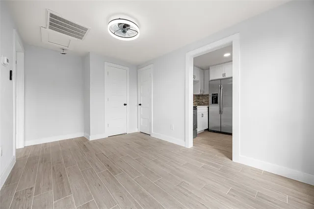 a view of a room with wooden floor and a ceiling fan