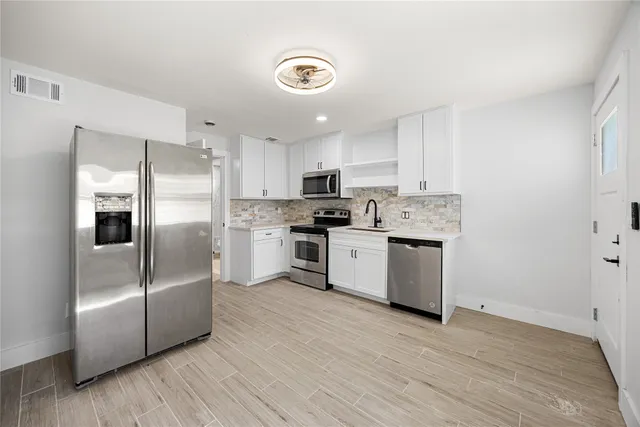 a kitchen with stainless steel appliances granite countertop a refrigerator and a stove top oven