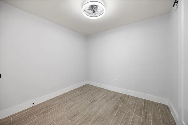 a view of a small space with wooden floor and a window