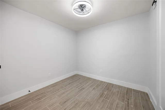 a view of a small space with wooden floor and a window
