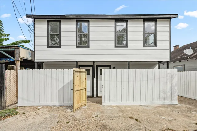 a view of a house with wooden fence