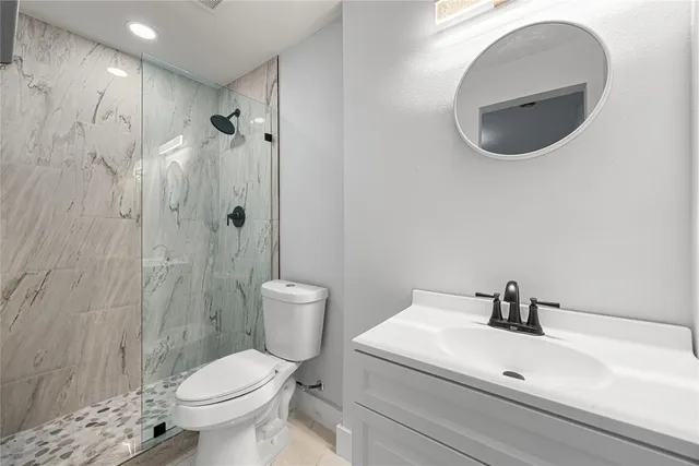 a white toilet sitting next to a bathroom sink
