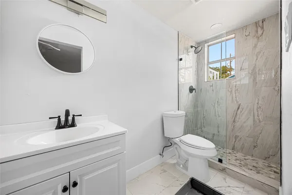 a bathroom with a sink a toilet and shower