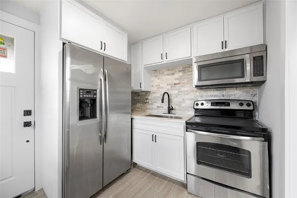 a kitchen with stainless steel appliances a stove a microwave and a refrigerator