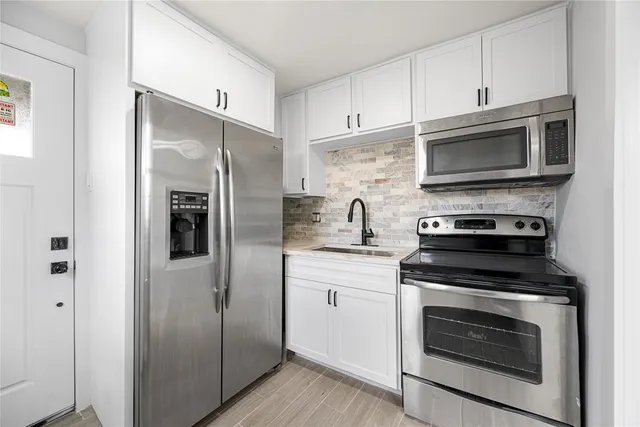 a kitchen with stainless steel appliances a stove a microwave and a refrigerator