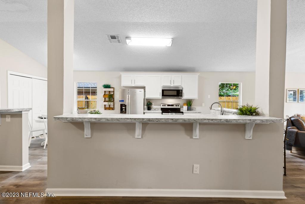 1652 Spring Oaks Lane Jacksonville, FL 32221 - Photo 13 of 37 a kitchen with stainless steel appliances a sink a stove and white cabinets