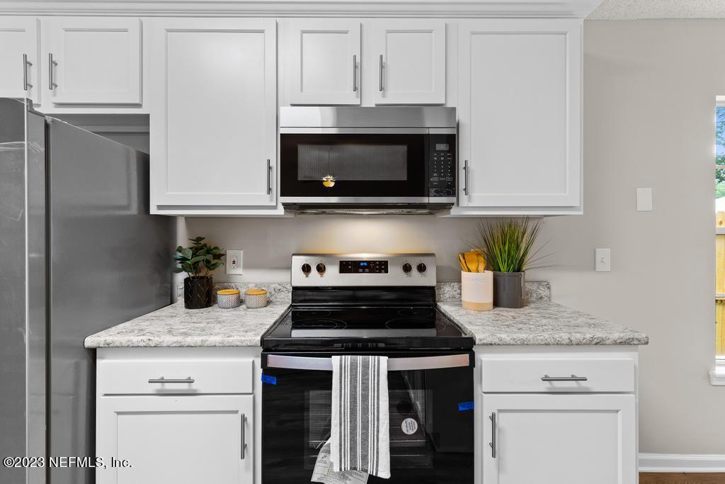 1652 Spring Oaks Lane Jacksonville, FL 32221 - Photo 18 of 37 a kitchen with granite countertop white cabinets and a stove a oven with white countertops