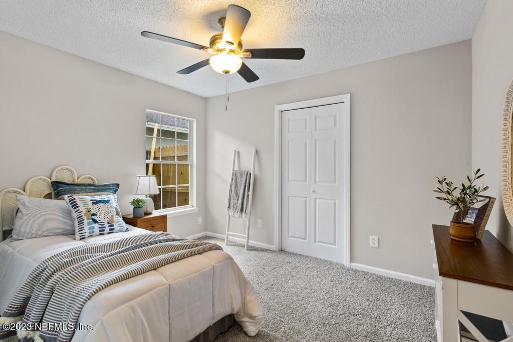 1652 Spring Oaks Lane Jacksonville, FL 32221 - Photo 23 of 37 a bedroom with a bed and a chandelier