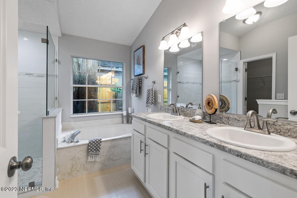 1652 Spring Oaks Lane Jacksonville, FL 32221 - Photo 29 of 37 a bathroom with a granite countertop sink a large mirror and shower