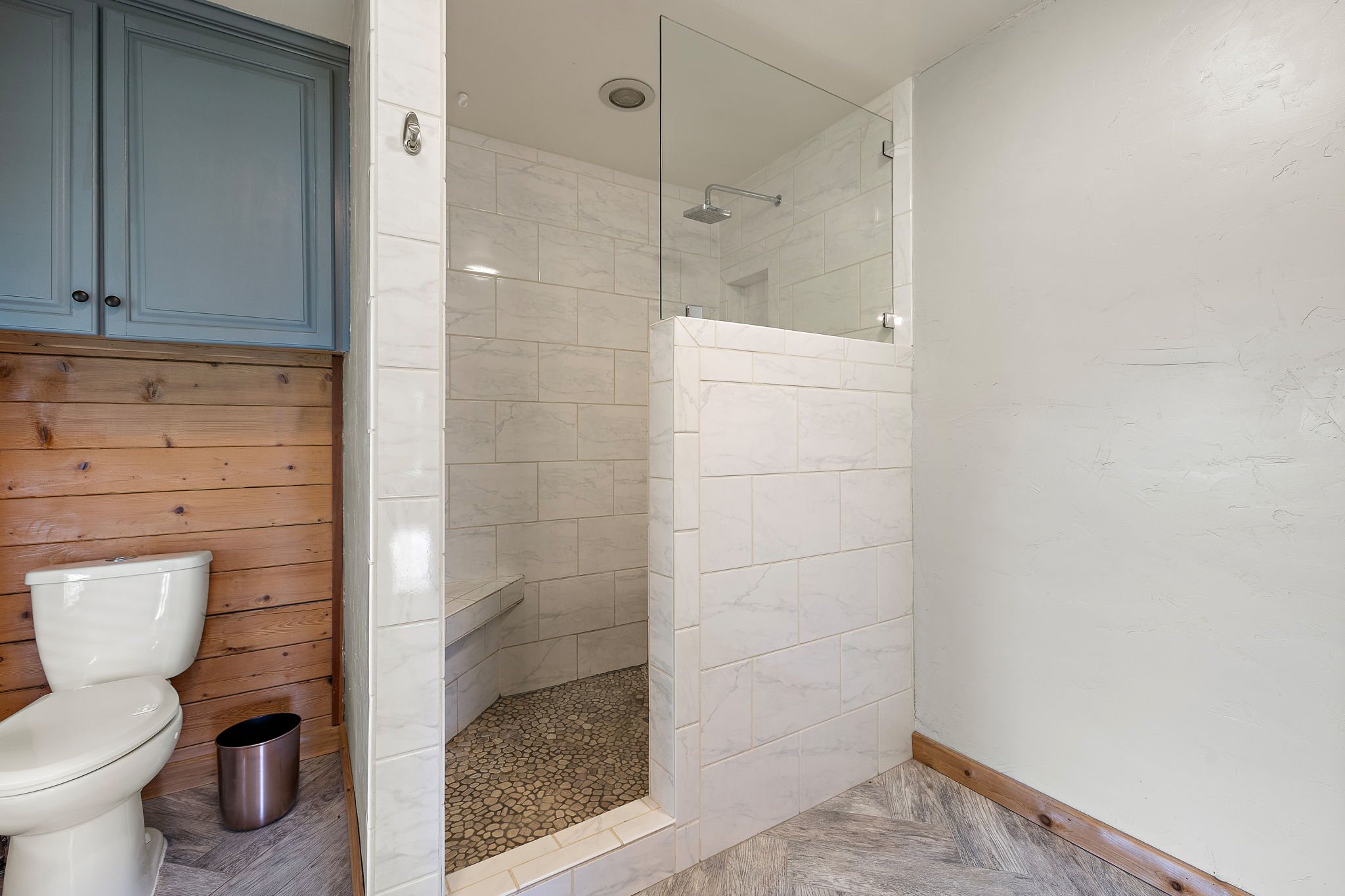 571 Balch Road Elgin, TX 78621 - Photo 17 of 33 Spacious shower with clear glass enclosure, white subway tile surround, pebble floor, and integrated bench seating