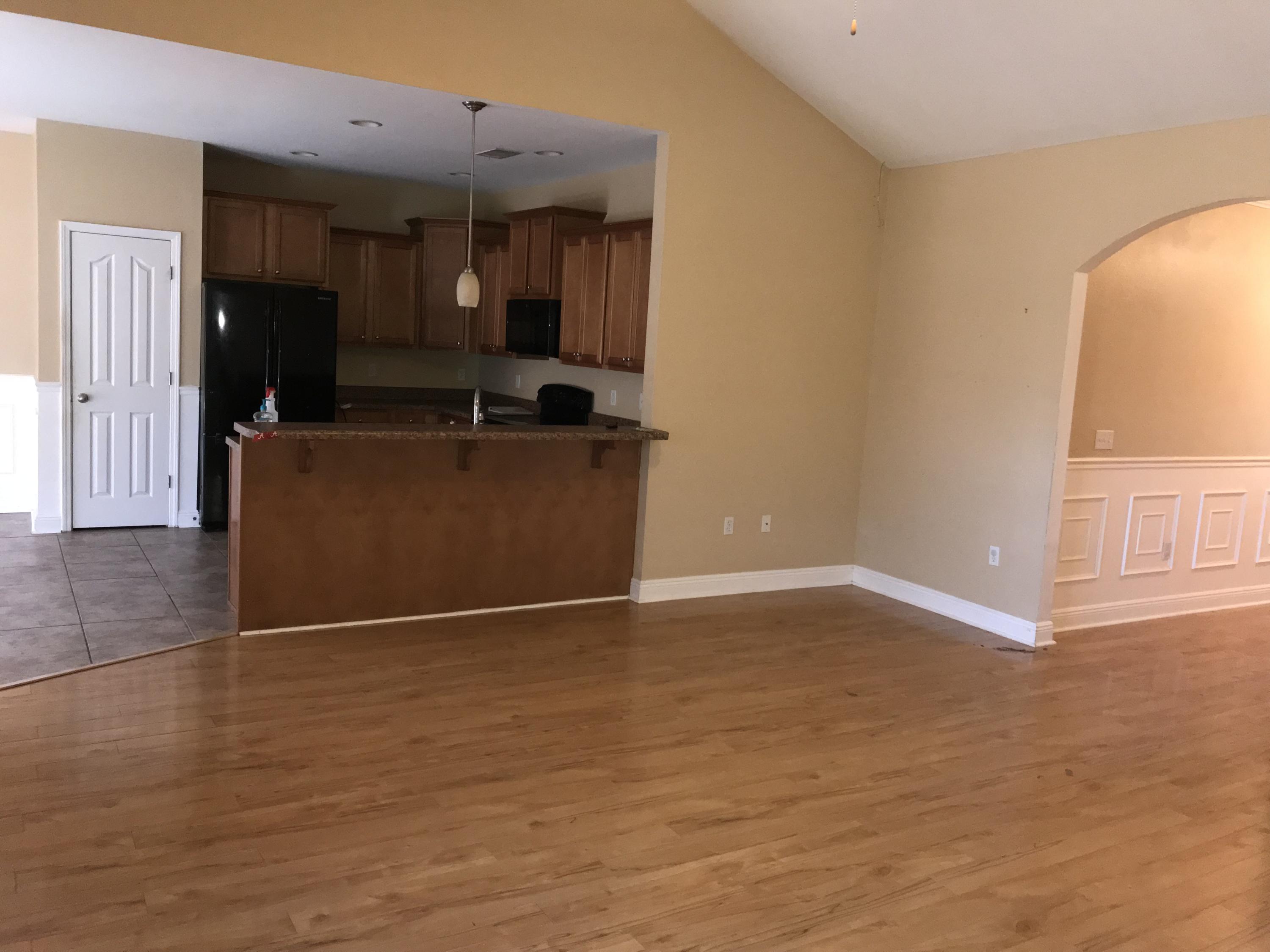 402 Wych Circle Crestview, FL 32536 - Photo 10 of 17 an empty room with wooden floor and windows