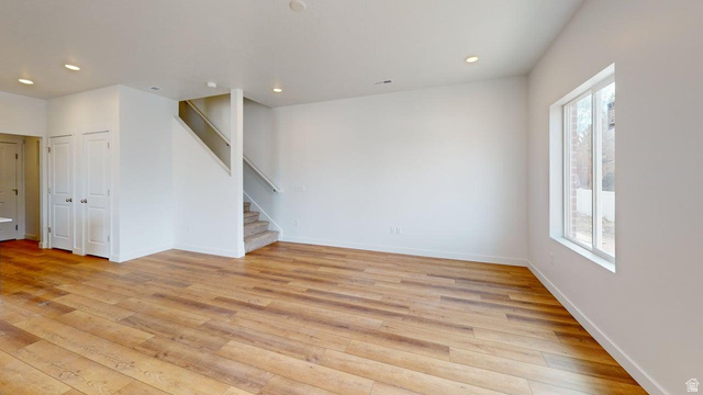 783 Pheasantbrook Drive, Unit 2A Centerville, UT 84014 - Photo 6 of 41 Open concept living space featuring wood-finish flooring, recessed lighting, a white framed window, and a carpeted staircase