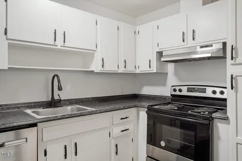 a kitchen with granite countertop white cabinets and stainless steel appliances
