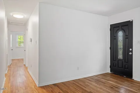a view of a room with wooden floor and a bathroom